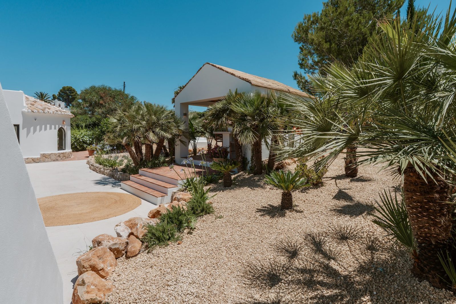 Exterior view of a beautiful 4-bedroom villa in Javea, surrounded by lush gardens - The Estates