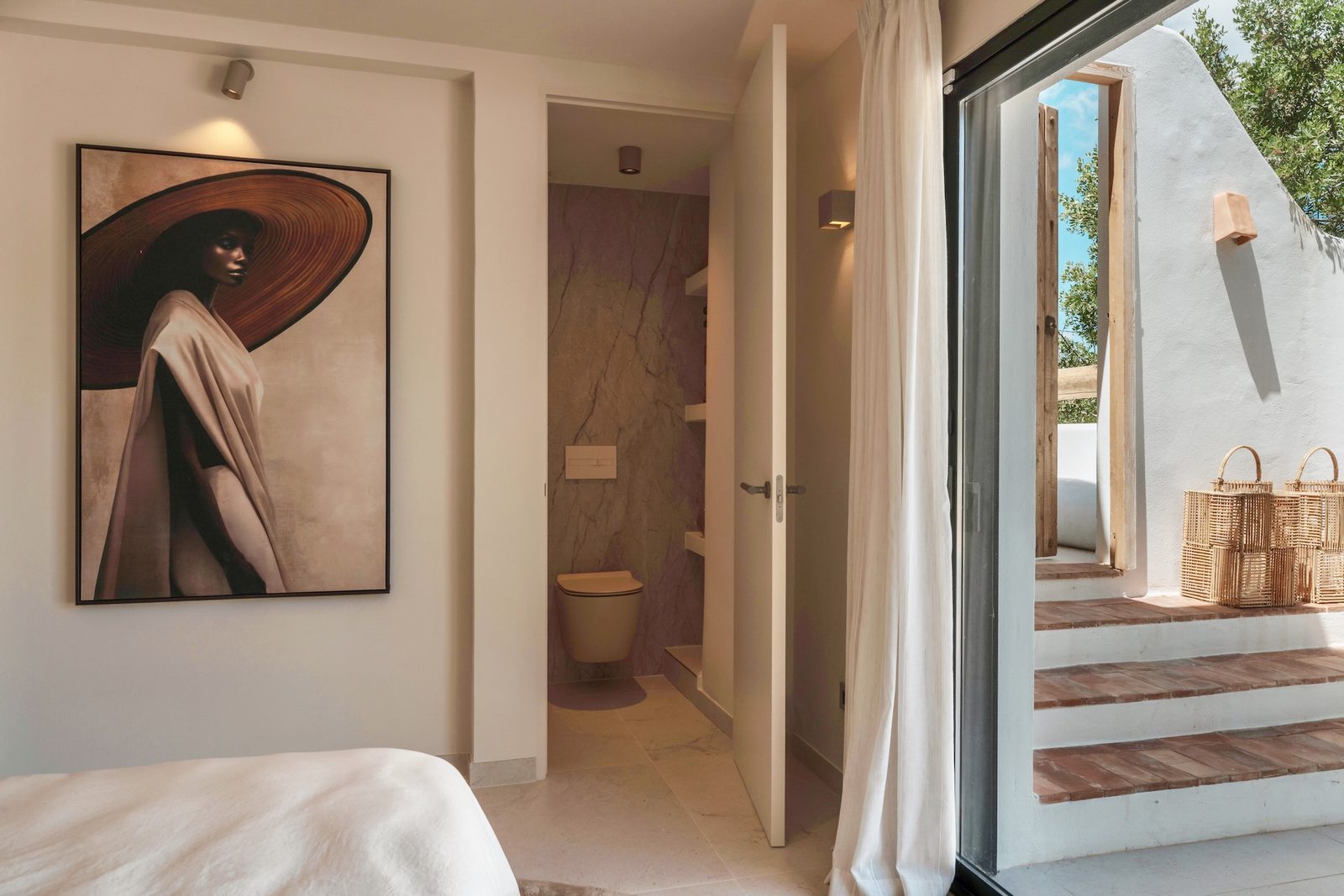 Stylish bedroom interior with artwork and an open doorway to a terrace in a 4-bedroom villa in Javea - The Estates