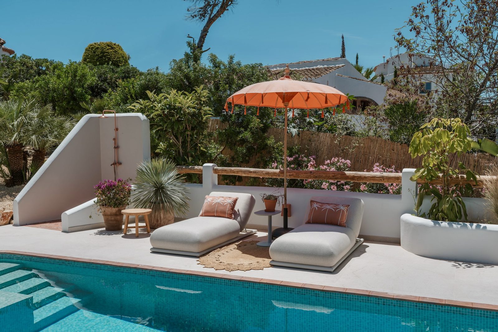 Relaxing poolside lounge area with a parasol at a 4-bedroom villa in Javea - The Estates