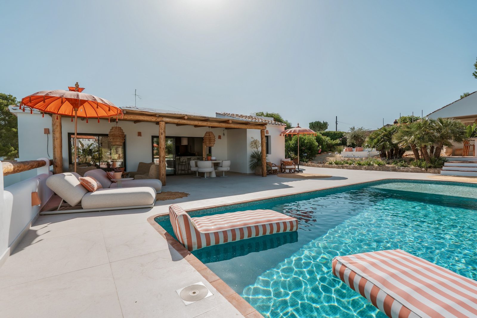 A stylish pool area with lounge seating and a pergola at a 4-bedroom villa in Javea - The Estates