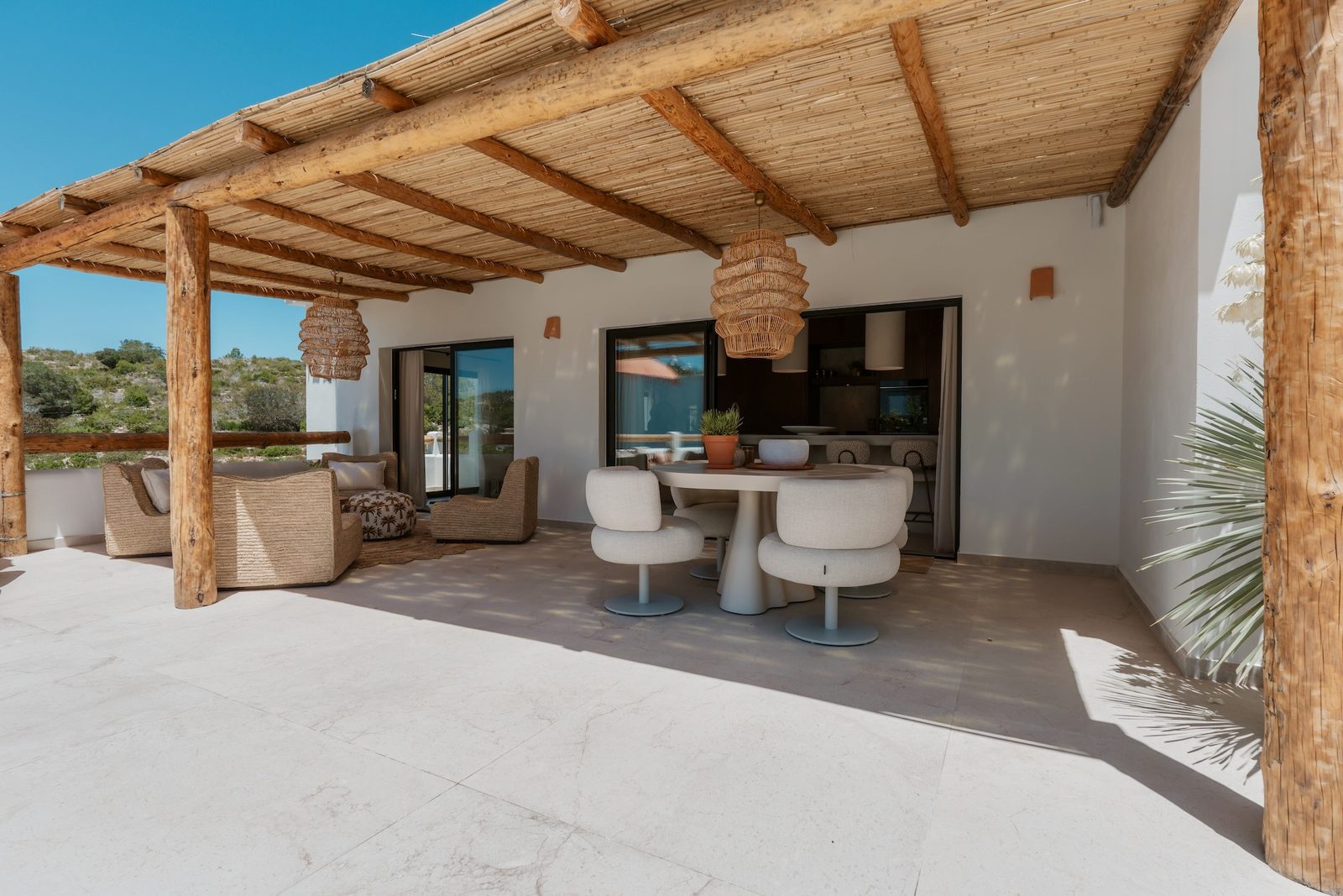 Outdoor dining area with a thatched roof on a 4-bedroom villa in Javea - The Estates