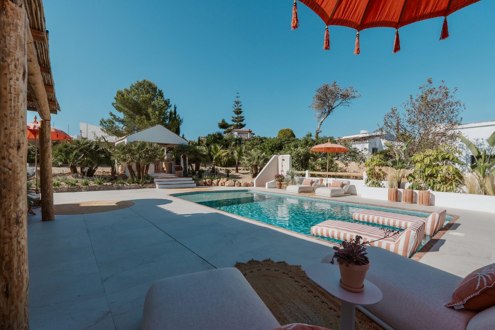A beautiful pool area with sun loungers and garden views of a 4-bedroom villa in Javea - The Estates