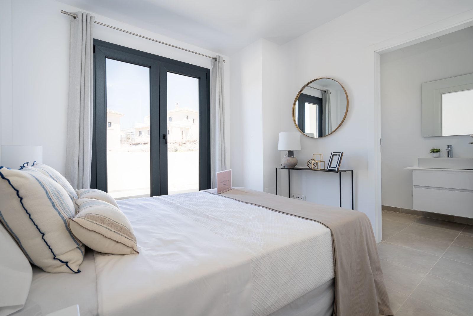 A bright bedroom interior with a view through French doors of a townhouse in Manacor - The Estates