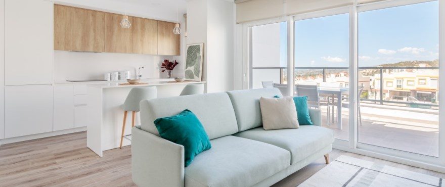 Open-plan living room and kitchen with balcony views of a 3-bedroom townhouse in Finestrat - The Estates