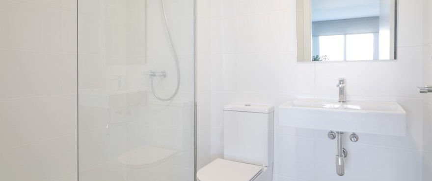 Modern white bathroom with walk-in shower, toilet and washbasin in a 3-bedroom townhouse in Finestrat - The Estates