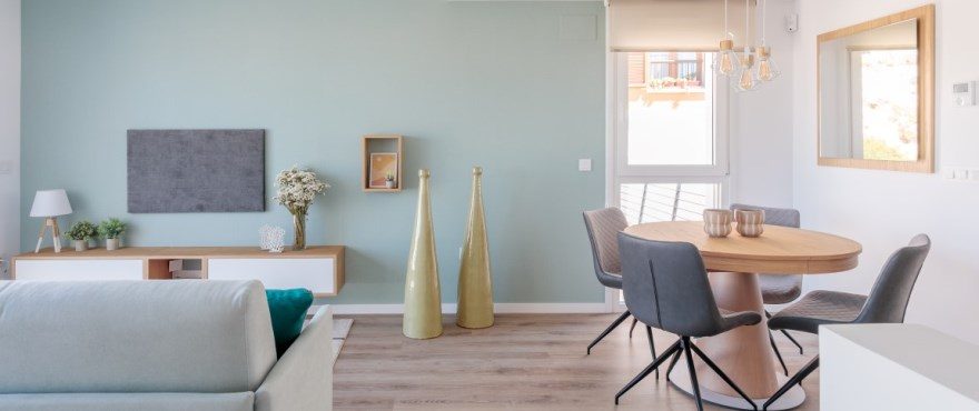 Open-plan living and dining room with sofa, round table, modern chairs and decorative furnishings in a 3-bedroom townhouse in Finestrat - The Estates