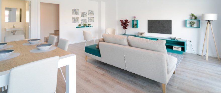 Open-plan living and dining room with contemporary furnishings and TV area of a 3-bedroom townhouse in Finestrat - The Estates