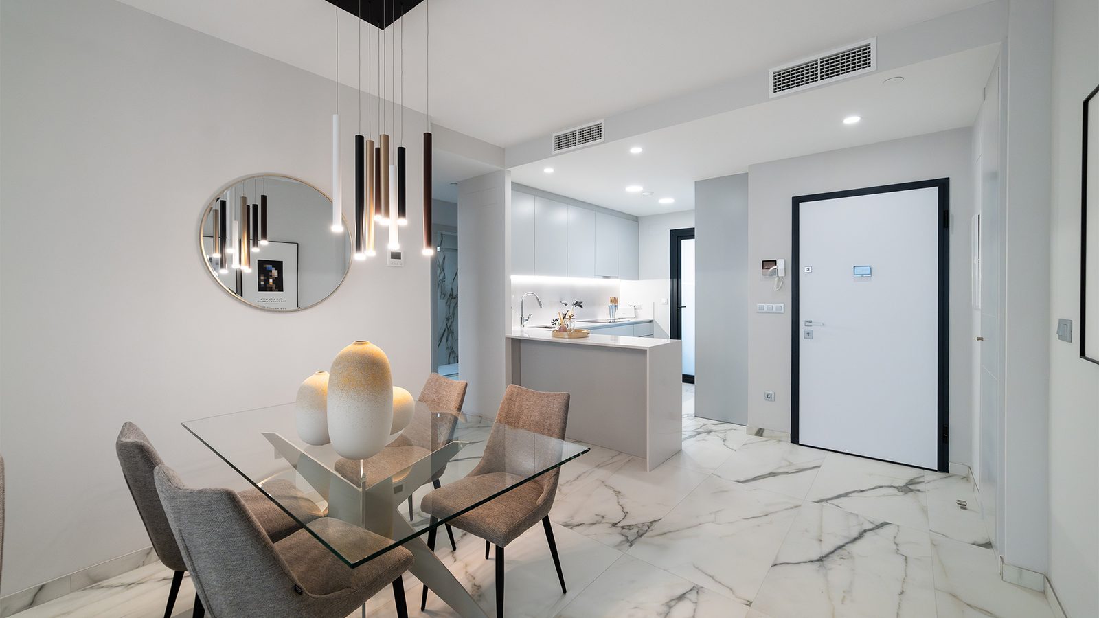 Modern dining area and open-plan kitchen with marble-effect flooring in a 3-bedroom apartment in Benidorm - The Estates