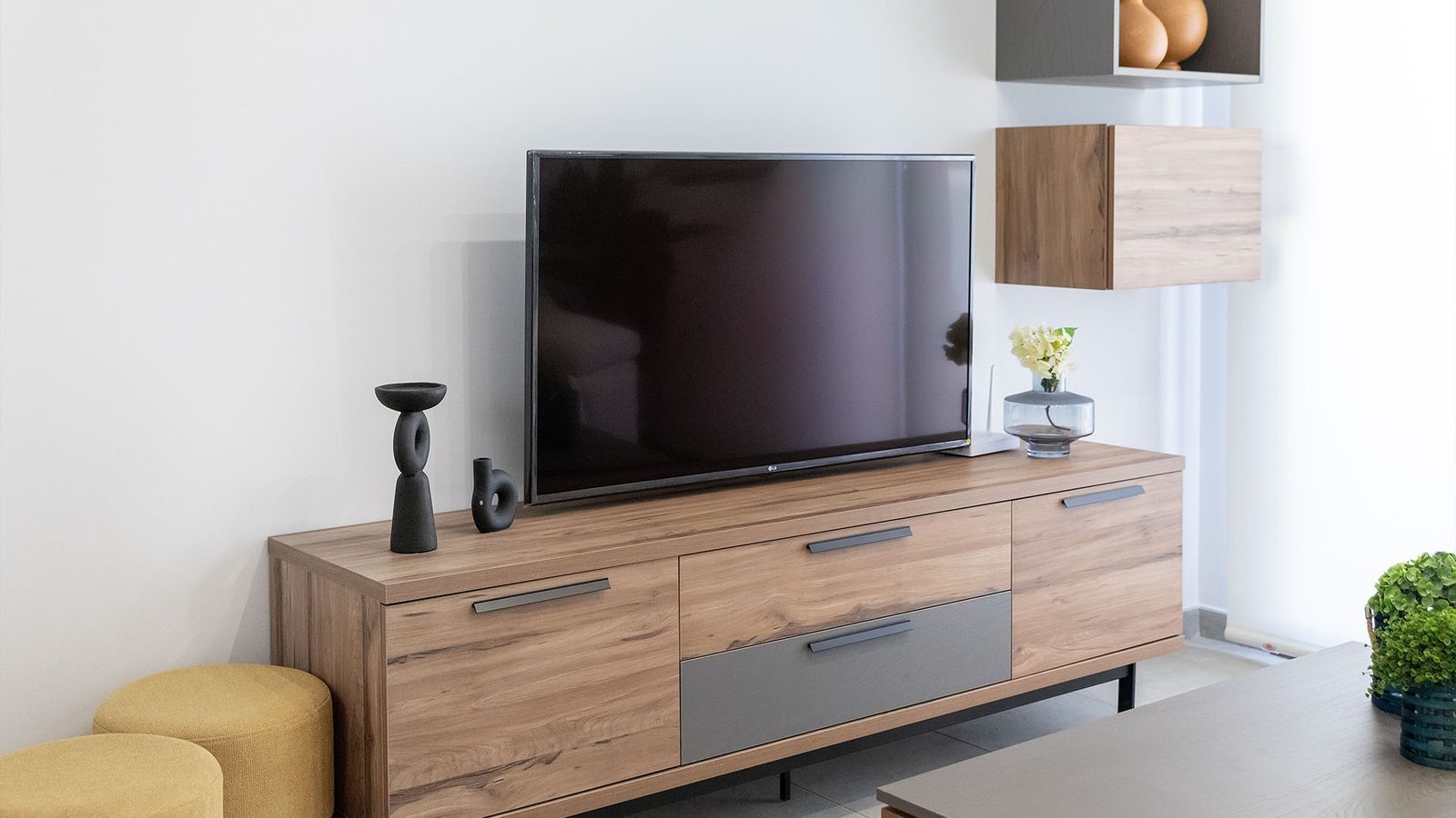 Modern living room with a TV, wooden media console and decorative furnishings in a 1-bedroom bungalow in Pulpí - The Estates