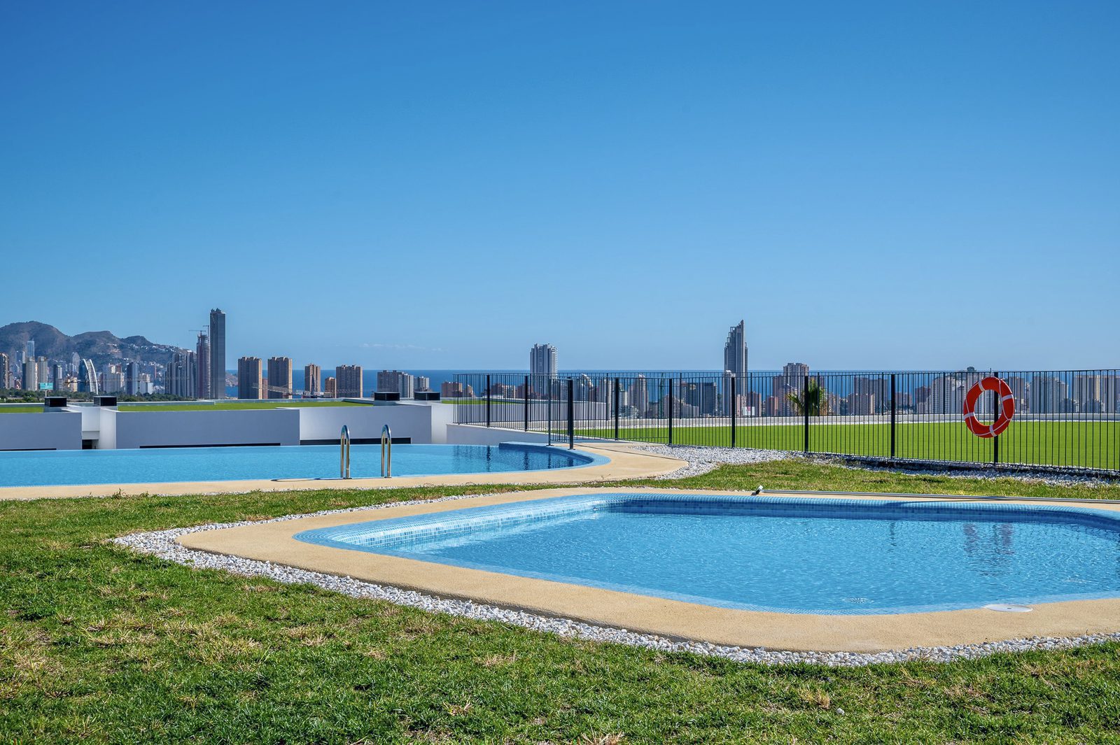 A swimming pool and garden with panoramic sea views of a 2-bedroom apartment in Finestrat - The Estates