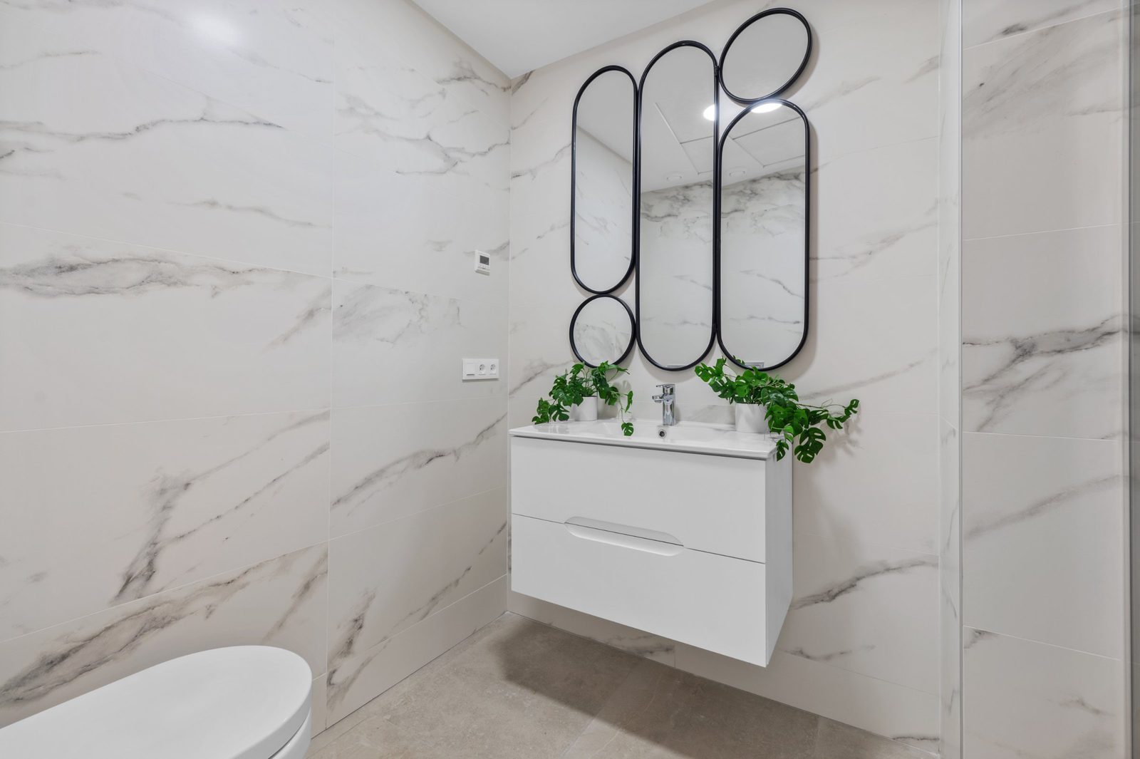 Stylish bathroom with modern vanity and mirror in a 2-bedroom apartment in Finestrat - The Estates