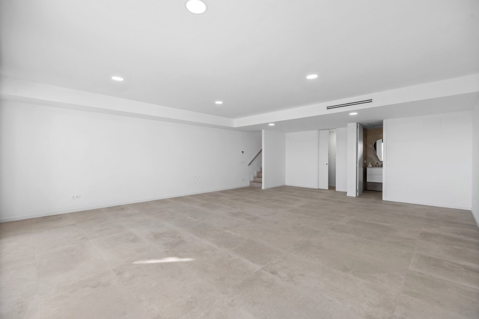 A bright, empty living room in a 2-bedroom apartment with sea and city views in Finestrat - The Estates