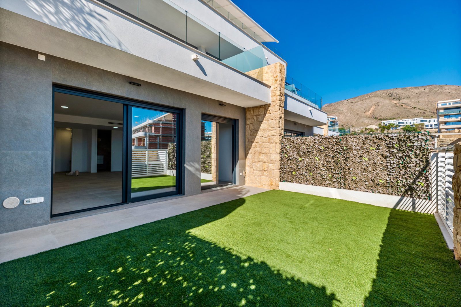 Exterior view of a modern 2-bedroom apartment with a garden and stunning sea views - The Estates