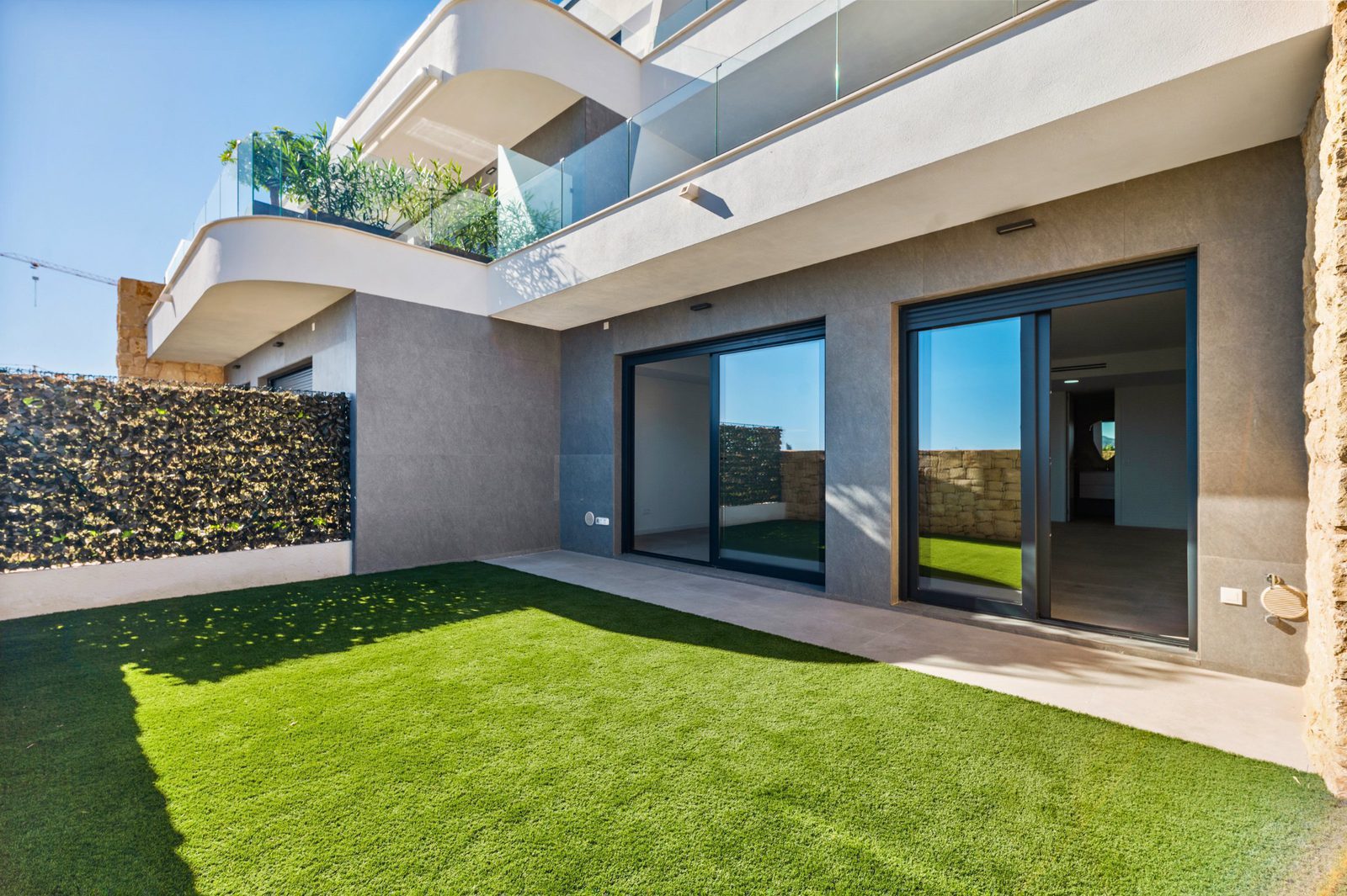 Exterior view of a modern 2-bedroom apartment with a garden and sea views in Finestrat - The Estates