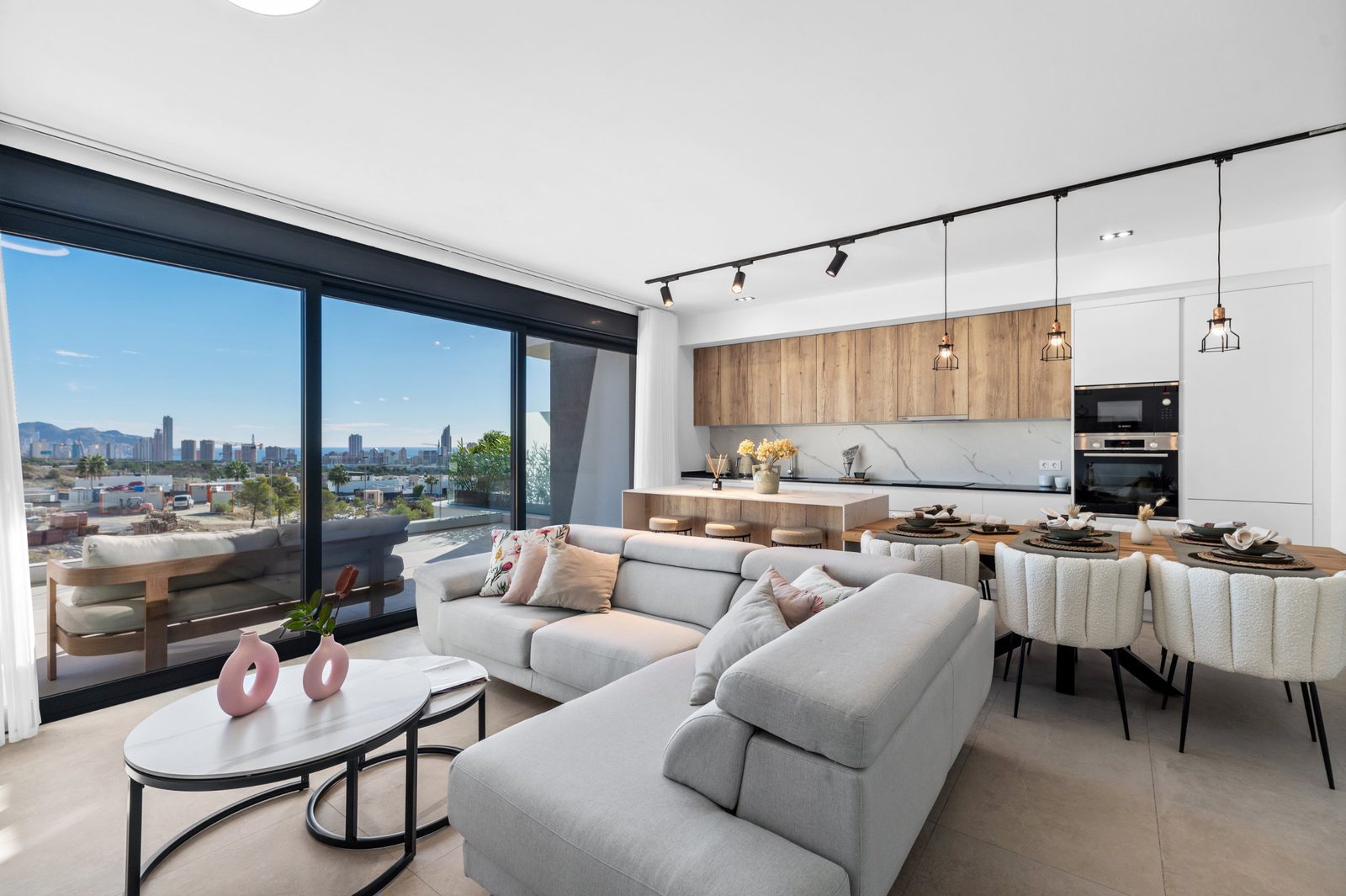 Modern living room and dining area with stunning sea and city views in a 2-bedroom apartment in Finestrat - The Estates