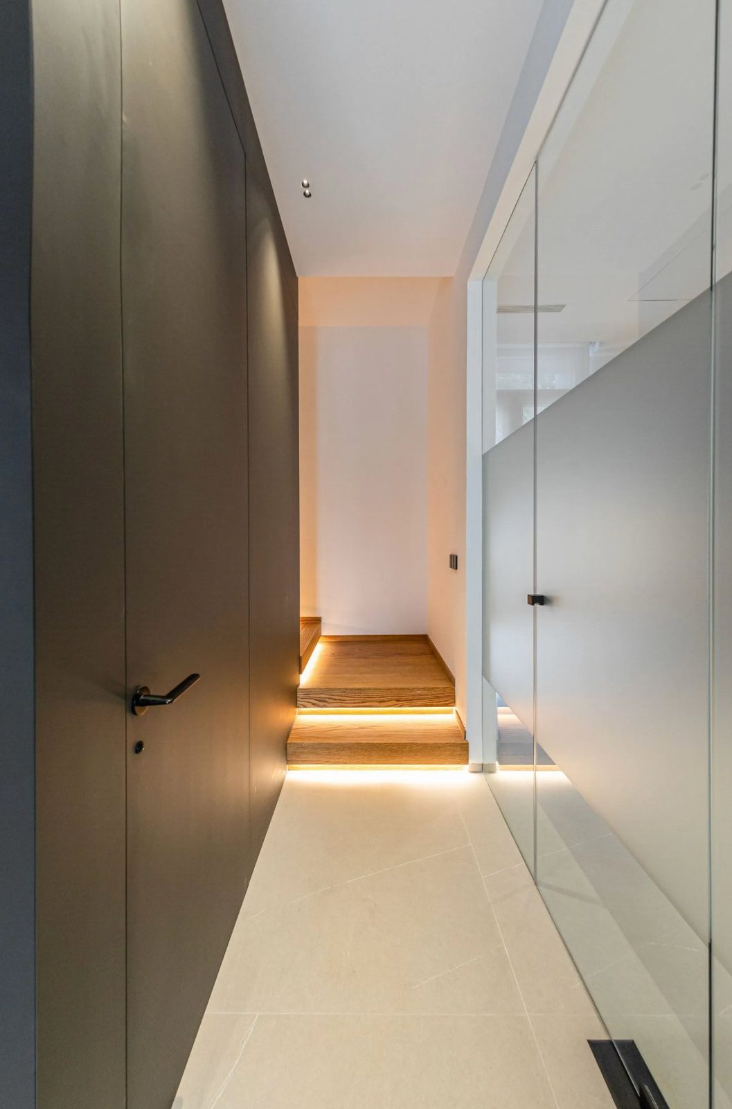 Modern hallway with illuminated steps and a sleek door in a 4-bedroom villa in Benidorm - The Estates