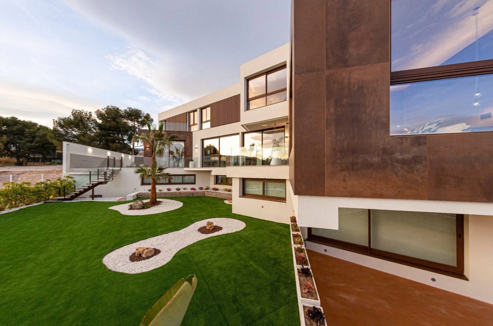 Modern exterior of a 4-bedroom villa in Benidorm with a manicured lawn and sea views - The Estates