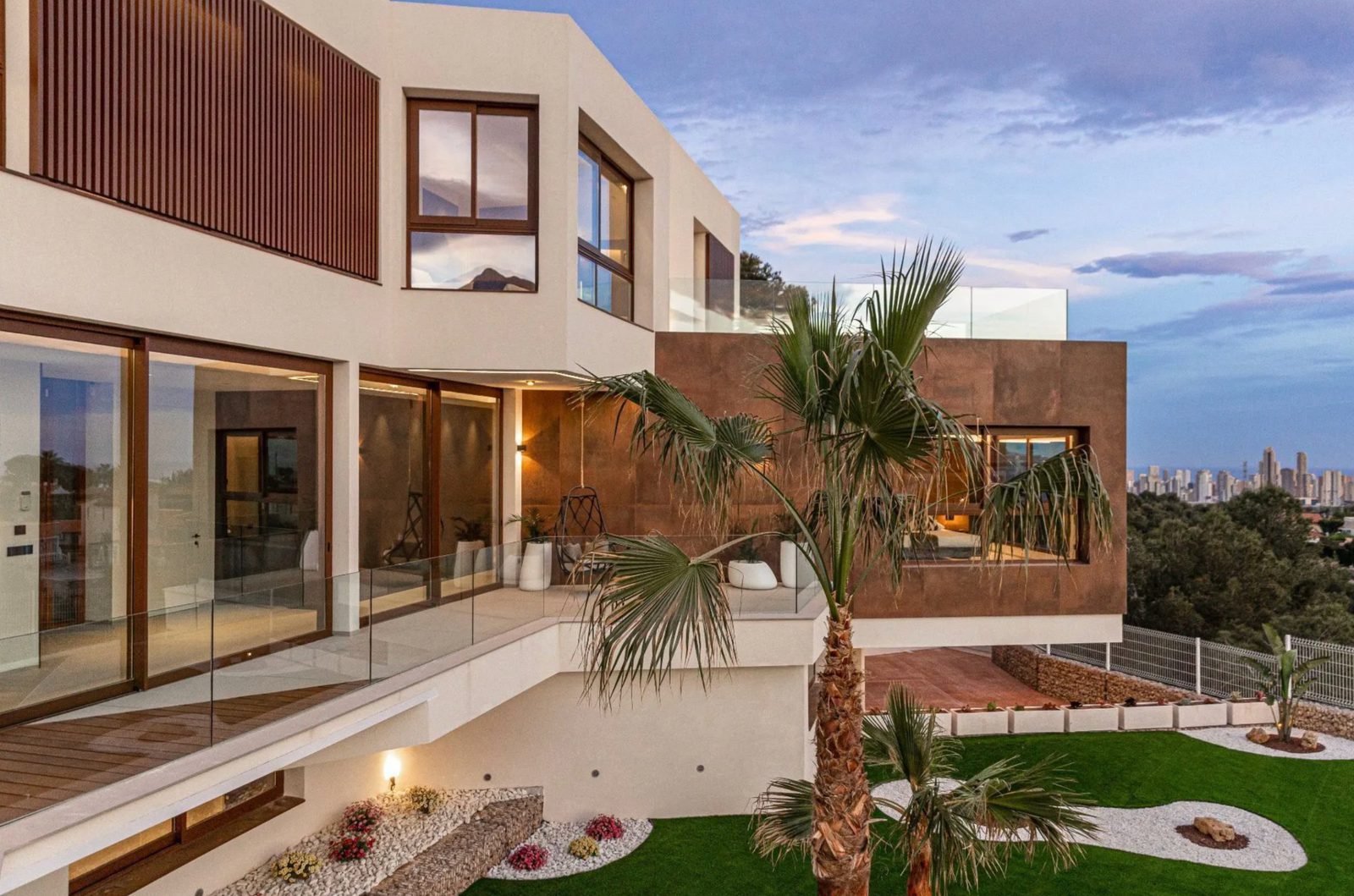 Modern exterior of a 4-bedroom villa in Benidorm with palm trees and sea views - The Estates