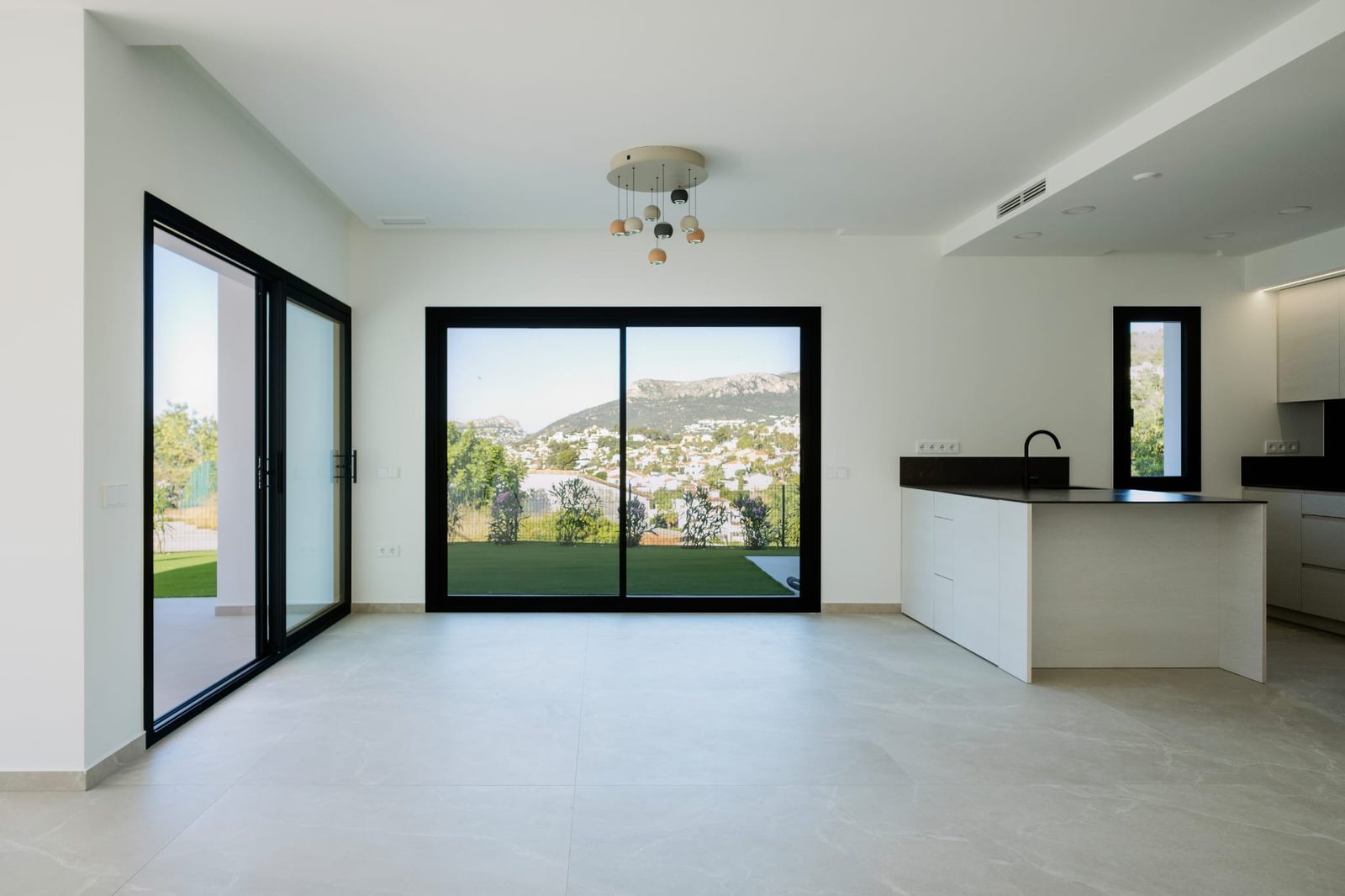 Bright living area with large windows showcasing mountain views of a 3-bedroom villa in Calpe - The Estates