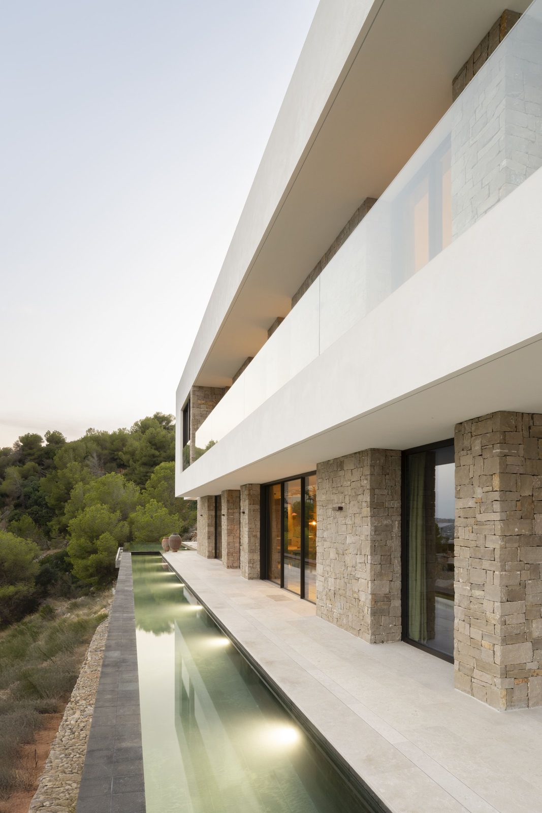 Modern villa exterior with a sleek swimming pool and stunning countryside views - The Estates