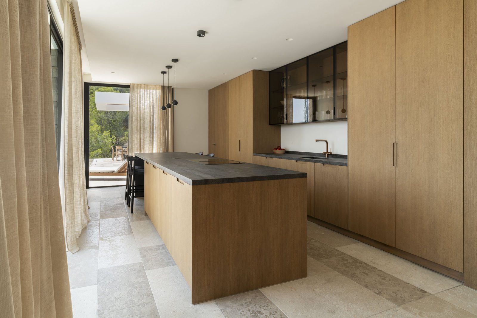 Modern kitchen with island and views of the garden in a 5-bedroom villa in Javea - The Estates