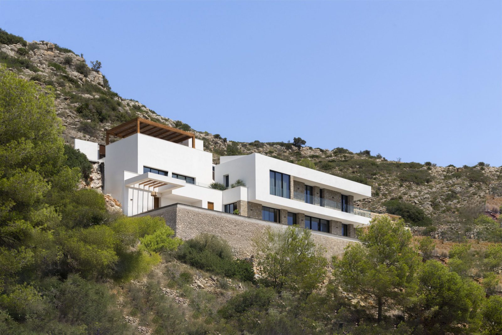A modern villa nestled into a hillside with mountain and countryside views - The Estates