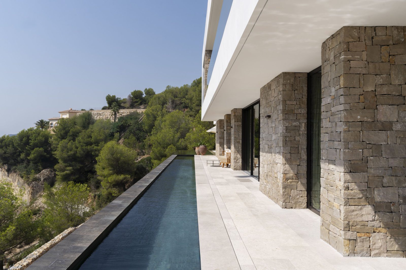 Modern villa exterior with a sleek pool and stunning mountain views of a 5-bedroom villa in Javea - The Estates