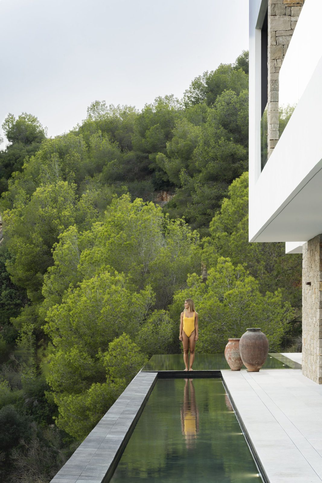 A modern villa's infinity pool overlooking lush green countryside in Javea - The Estates