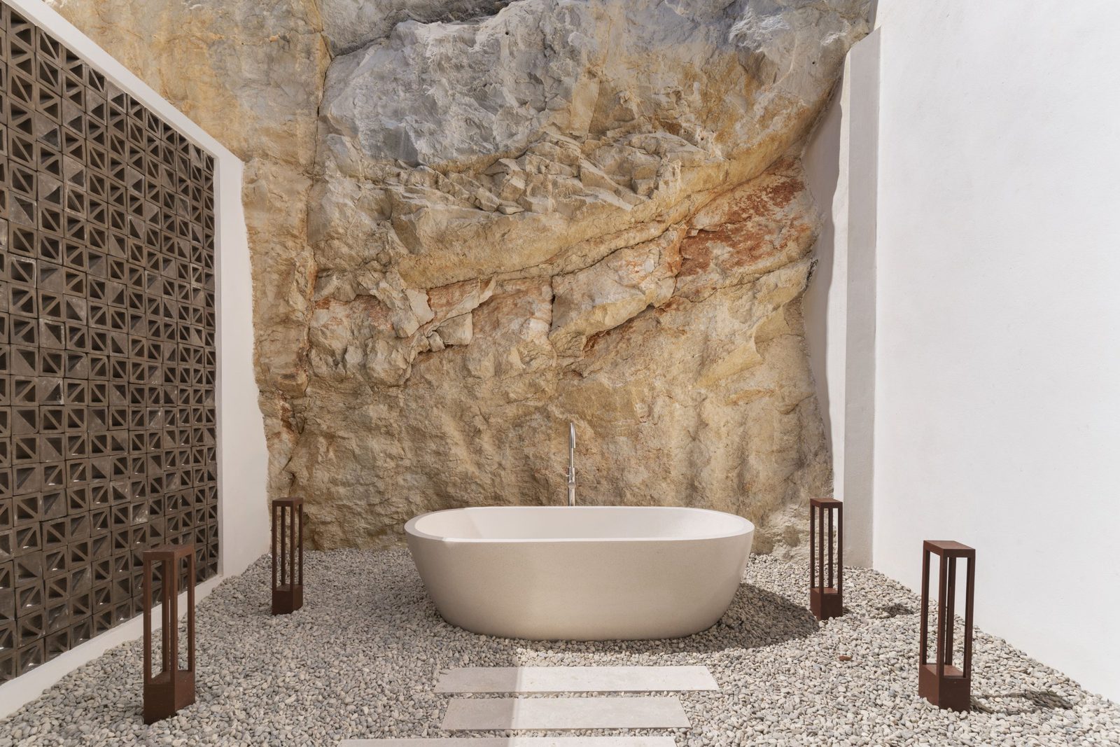 A luxurious bathtub nestled against a natural rock face in a 5-bedroom villa in Javea - The Estates