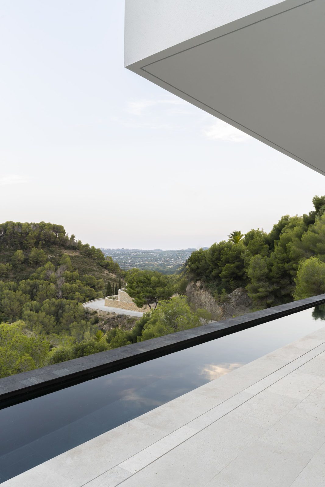 A modern pool overlooking sea, mountain, and countryside views of a 5-bedroom villa in Javea - The Estates