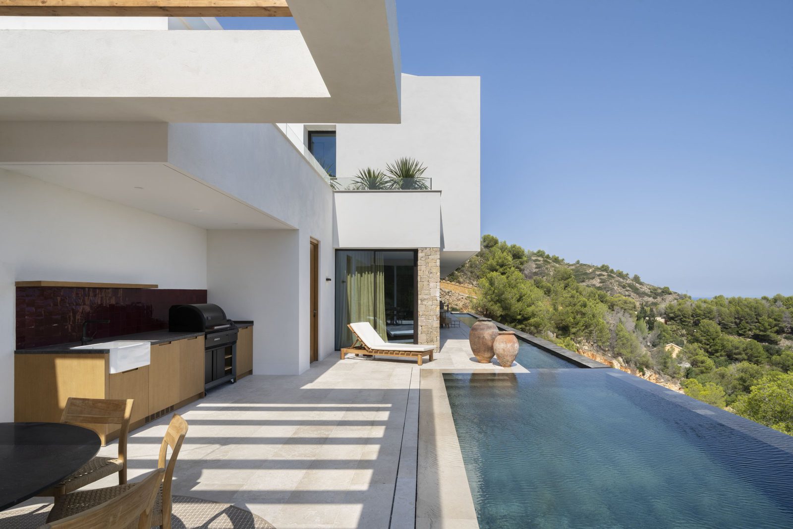 Outdoor kitchen and infinity pool with mountain and sea views of a 5-bedroom villa in Javea - The Estates