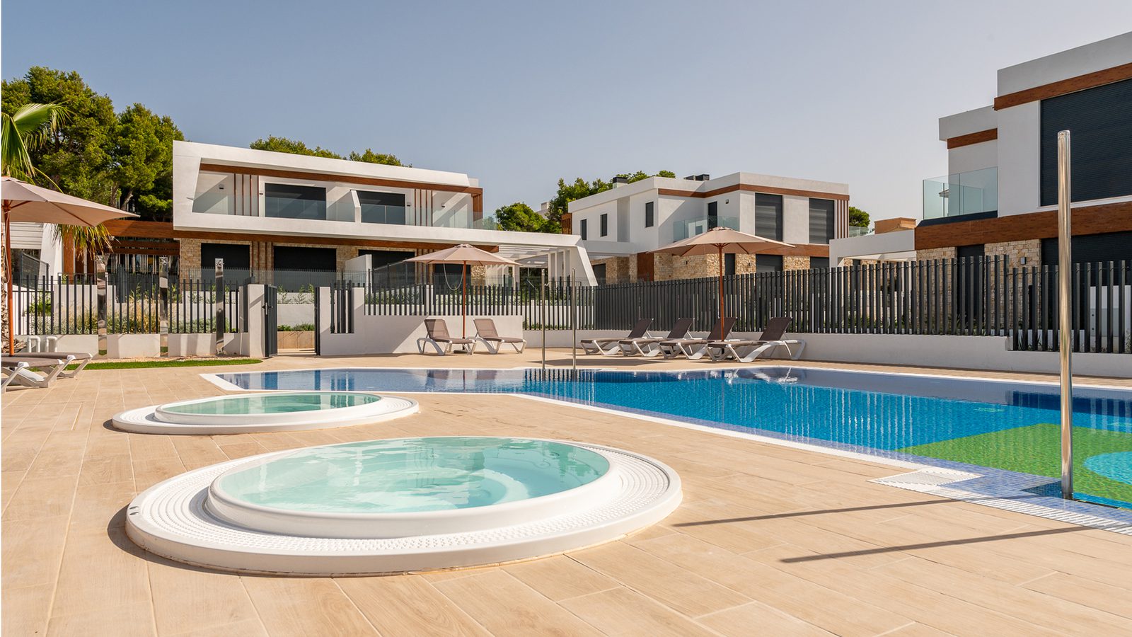 A beautiful pool area with sun loungers and a jacuzzi at a 3-bedroom semi-detached in Capdepera - The Estates