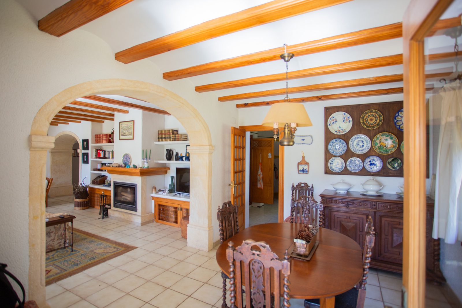 A bright living and dining area with wooden beams and decorative details in a 4-bedroom villa in Javea - The Estates
