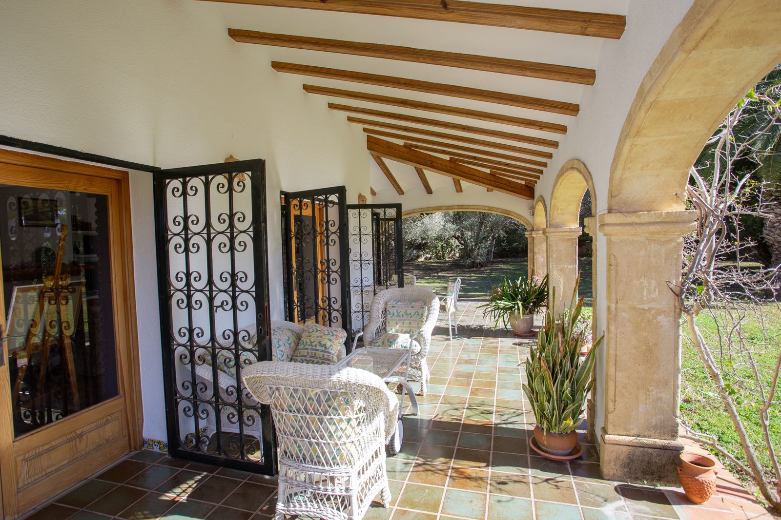 A charming covered terrace with seating overlooking the countryside of a 4-bedroom villa in Javea - The Estates