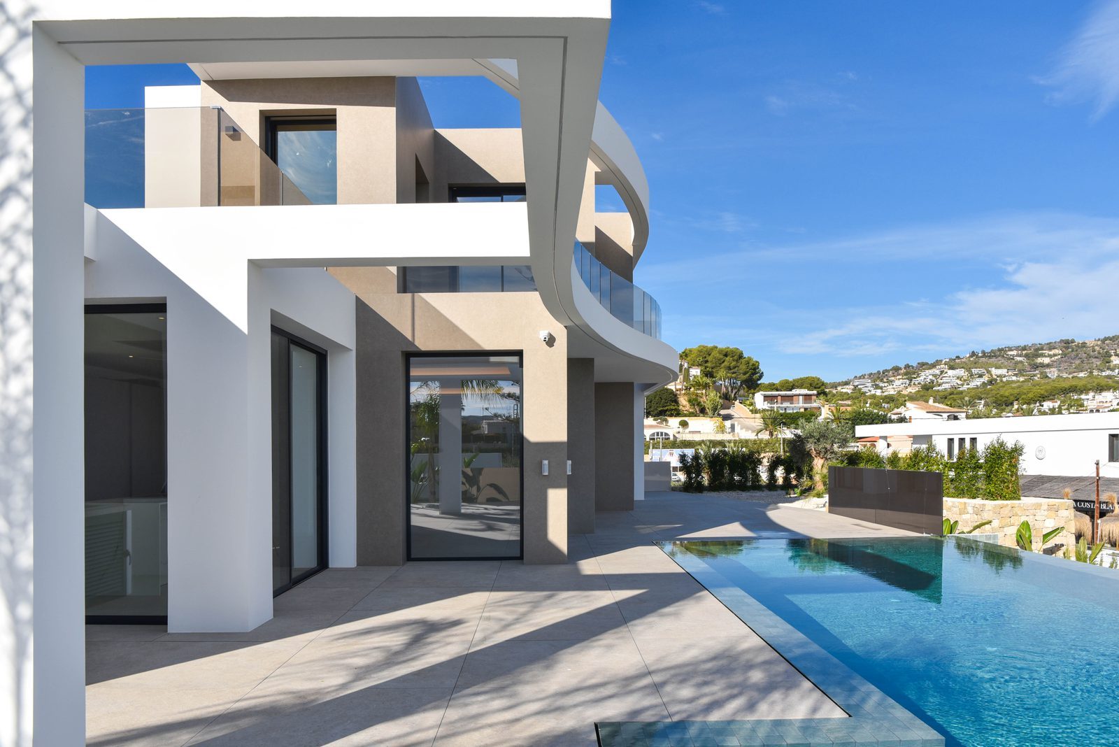 Modern villa exterior with infinity pool and hillside views of a 4-bedroom villa in Benissa - The Estates