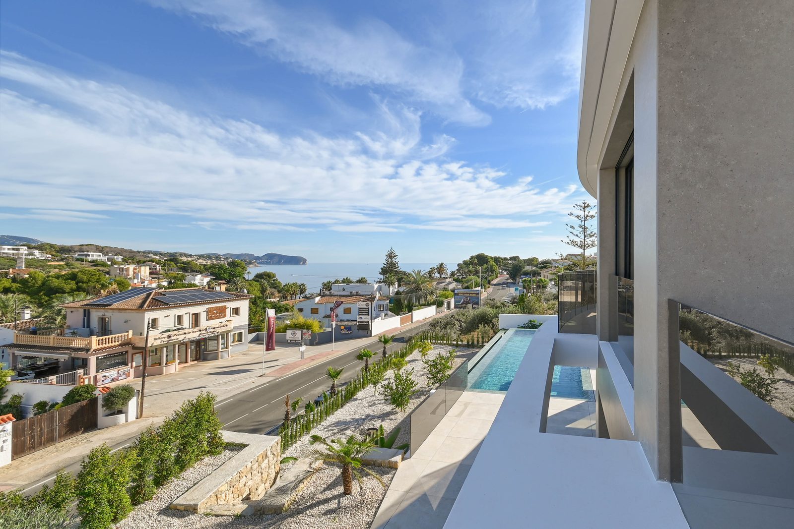 Sea views from a balcony overlooking the pool and coast of a 4-bedroom villa in Benissa - The Estates