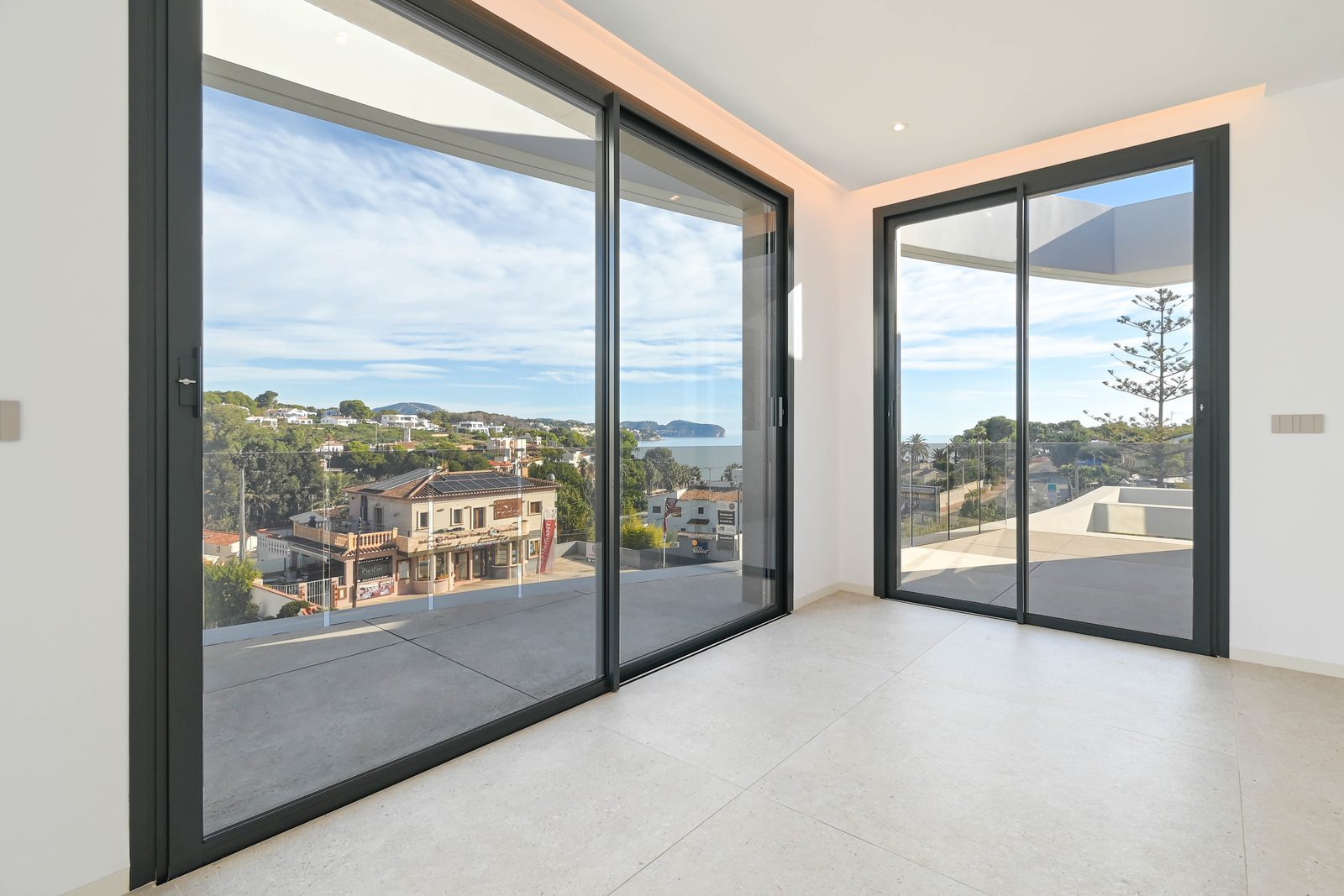 Bright modern room with floor-to-ceiling glass doors, terrace and sea views in La Fustera, part of