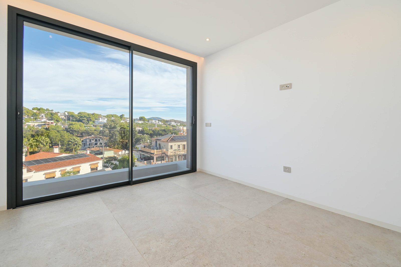 Bright empty bedroom with floor-to-ceiling window and hillside views in a 4-bedroom villa in Benissa - The Estates