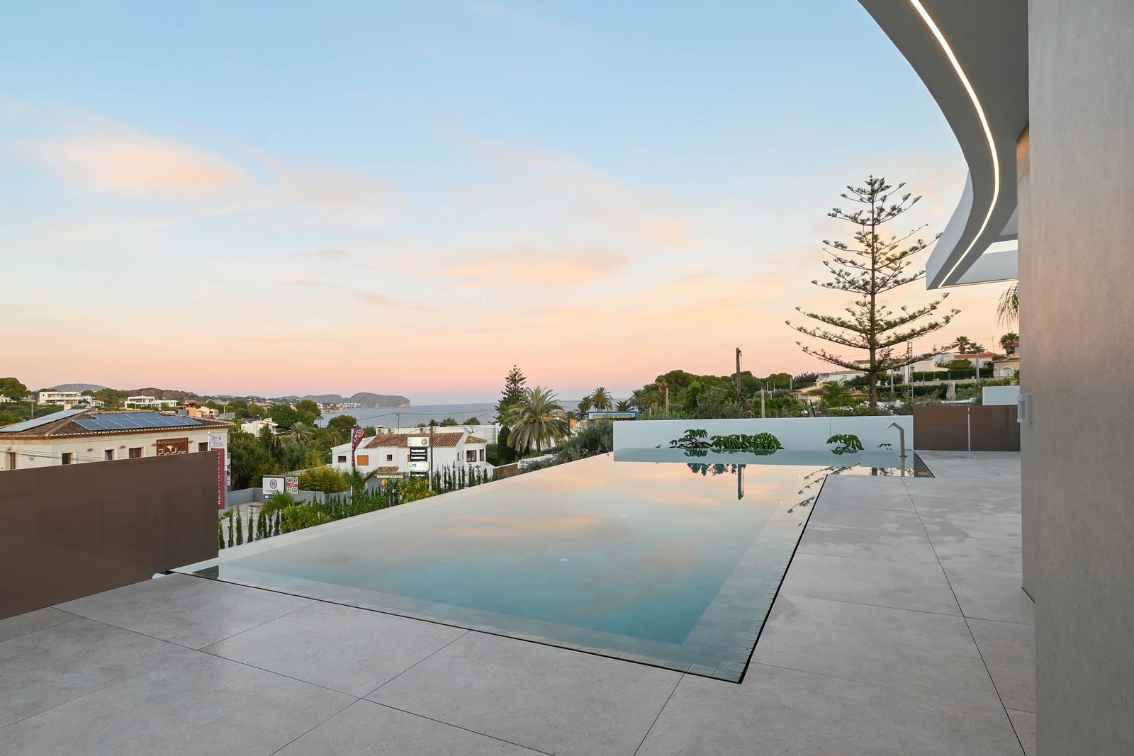 Infinity pool and sea views at sunset from a modern villa terrace in La Fustera, Benissa - The Estates