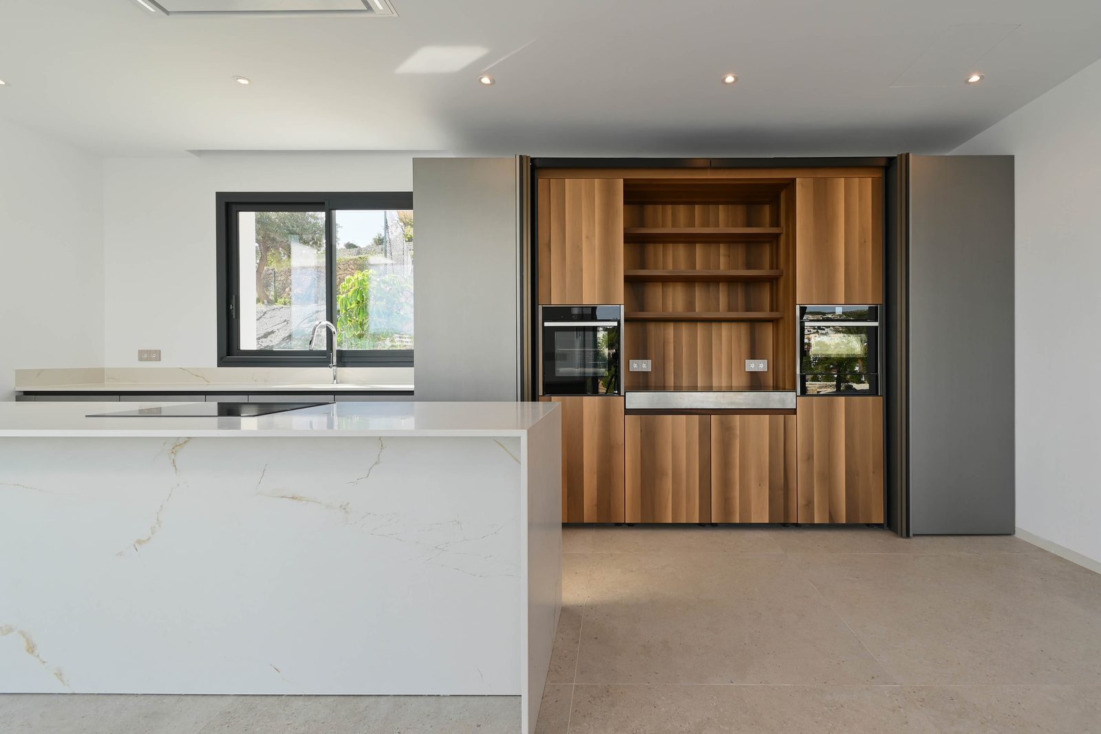 Modern kitchen with island and wood cabinetry of a 4-bedroom villa in Benissa - The Estates
