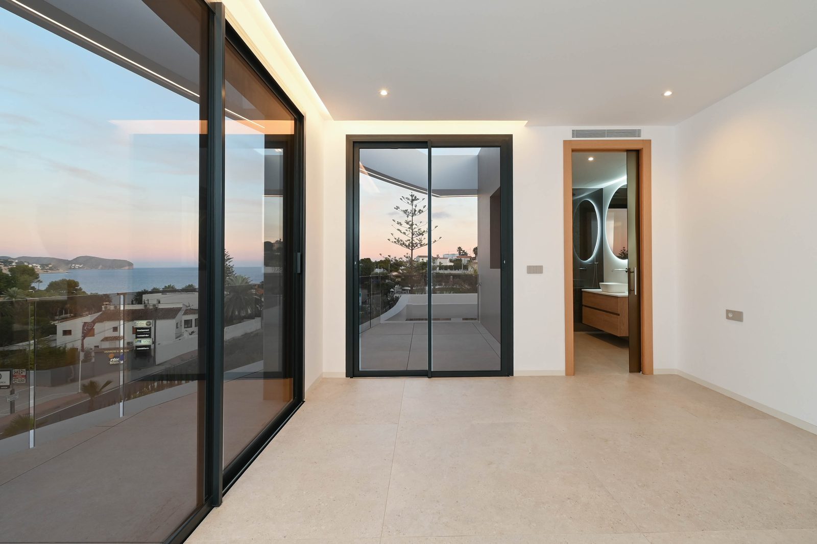 Bright modern interior with floor-to-ceiling windows, sea views
