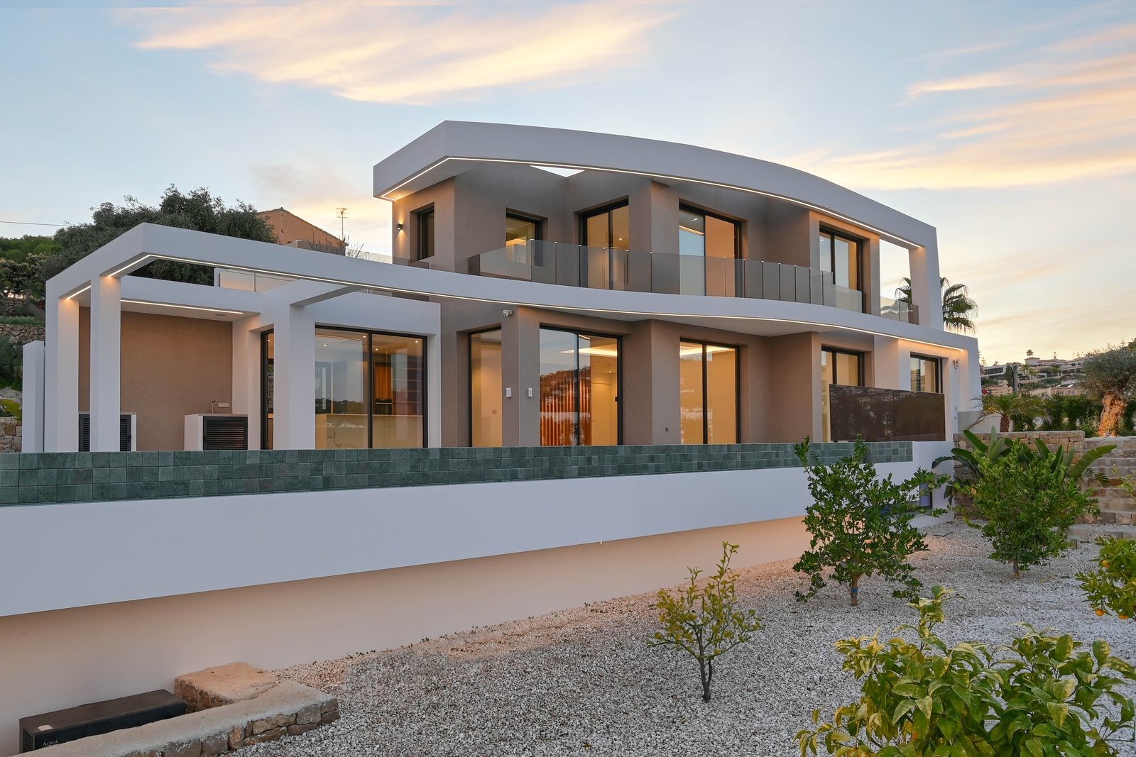 Modern exterior of a 4-bedroom villa with balconies and citrus garden at dusk in Benissa - The Estates
