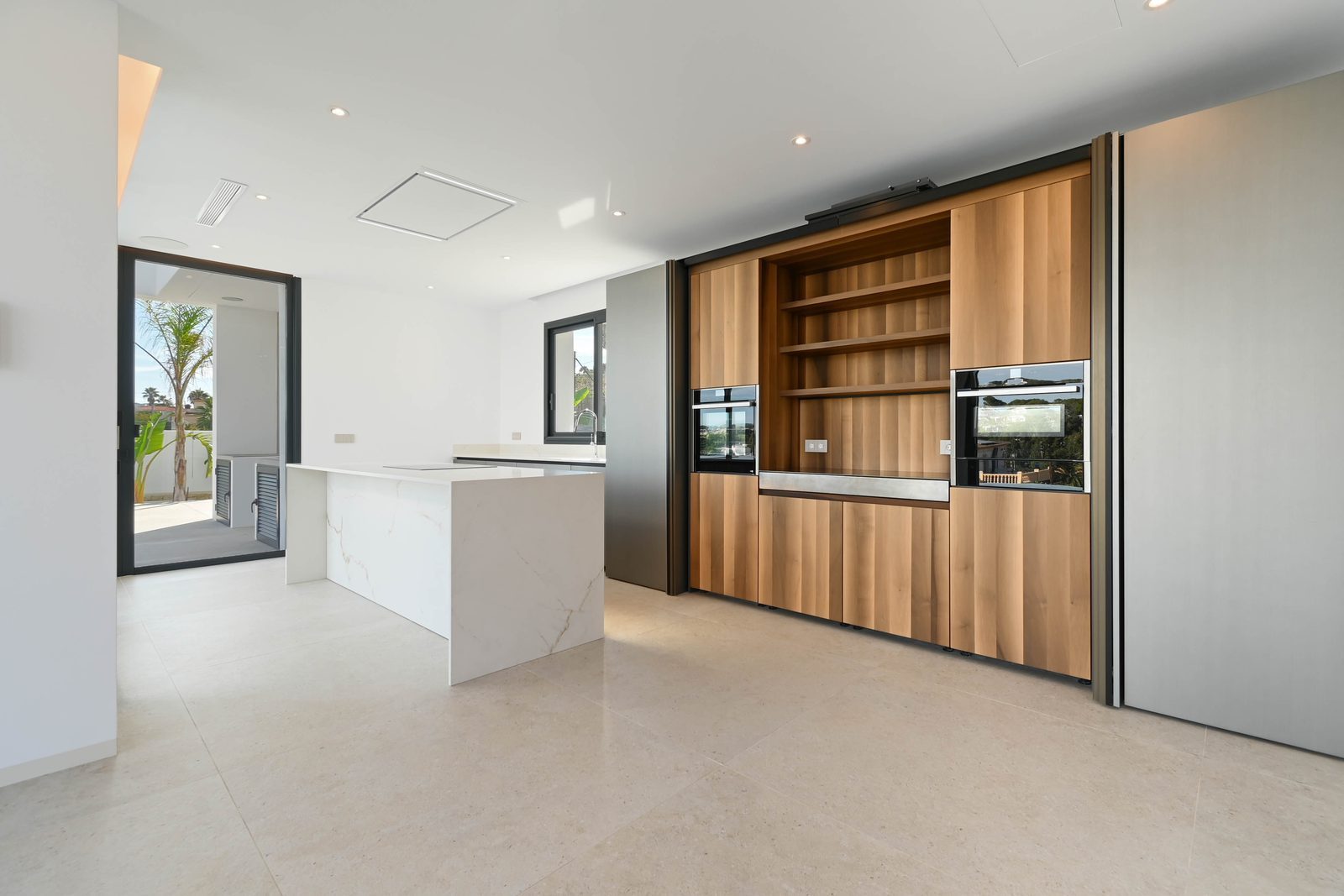 Modern kitchen with island, timber cabinetry and integrated appliances in a 4-bedroom villa in Benissa - The Estates