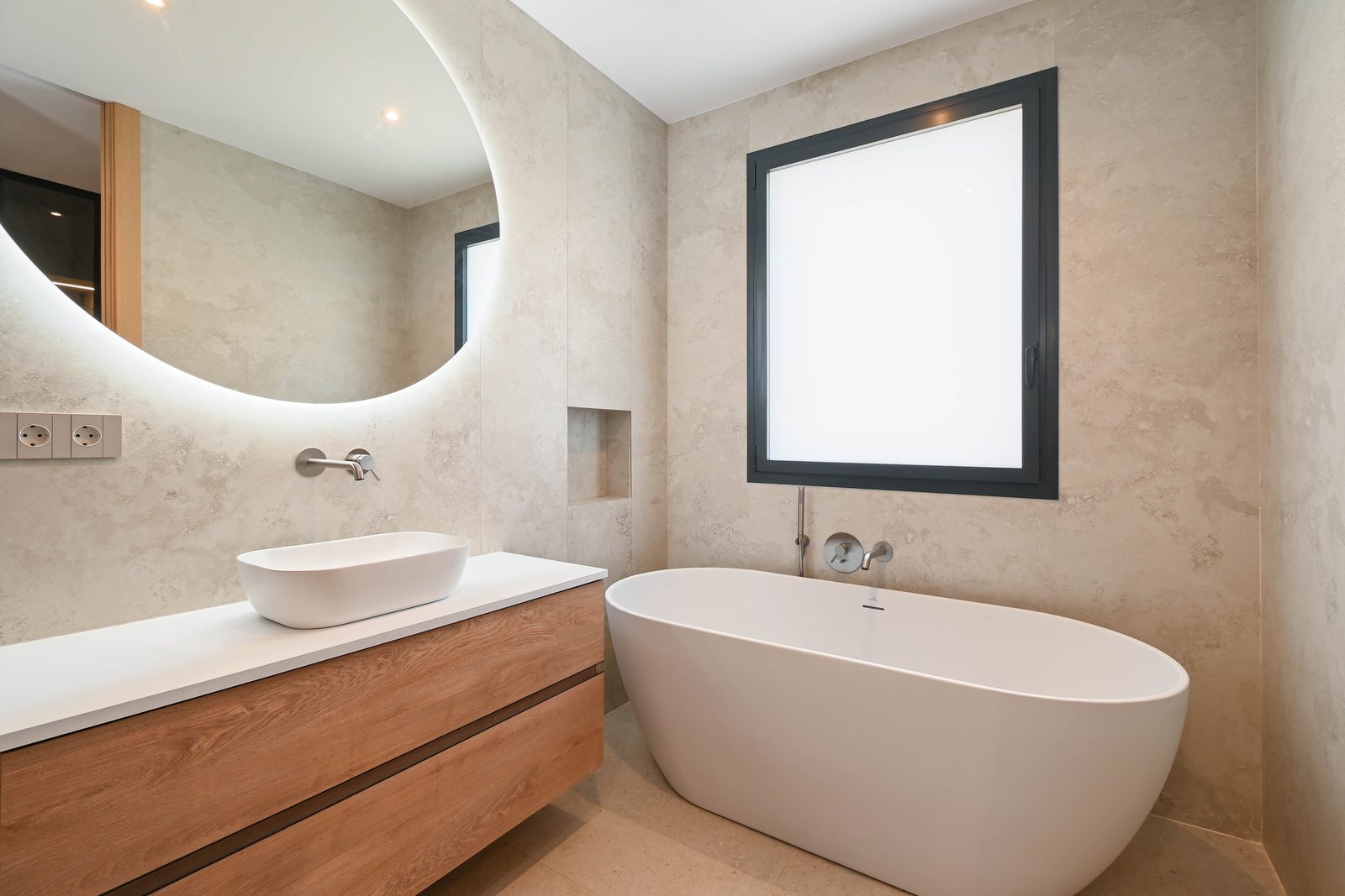 Modern bathroom with freestanding bathtub, vessel sink and illuminated mirror of a 4-bedroom villa in Benissa —