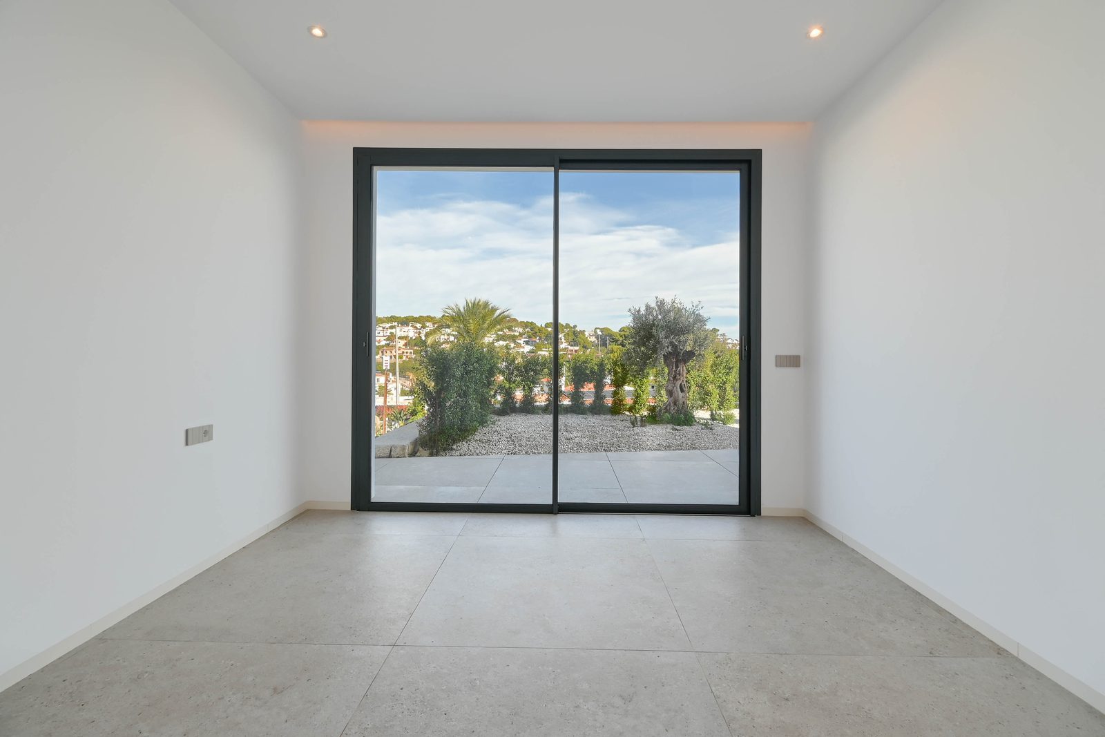 Bright modern room with tiled floor and sliding glass doors