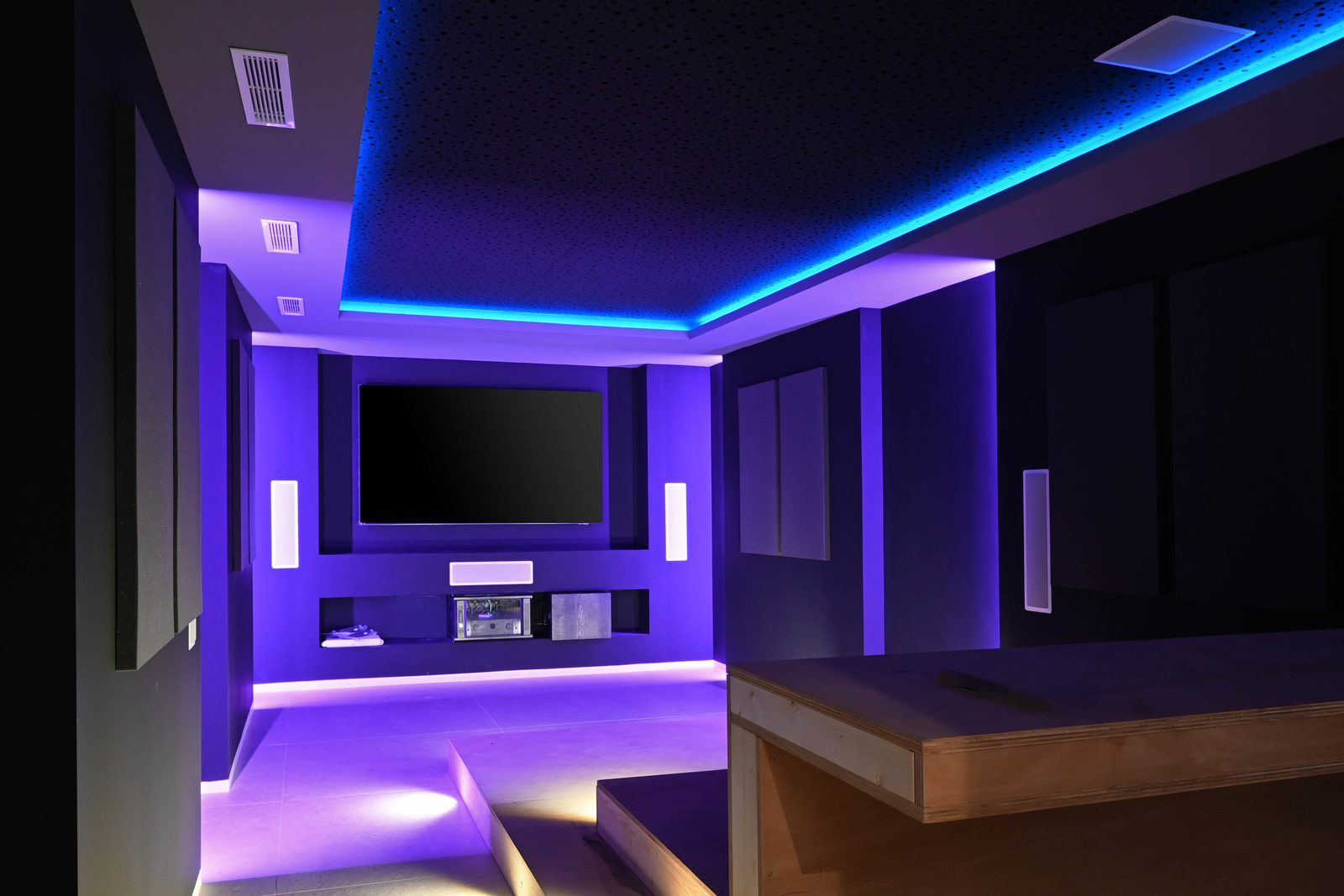Home cinema with large screen, surround sound and vibrant blue and purple lighting in a 4-bedroom villa in Benissa - The Estates