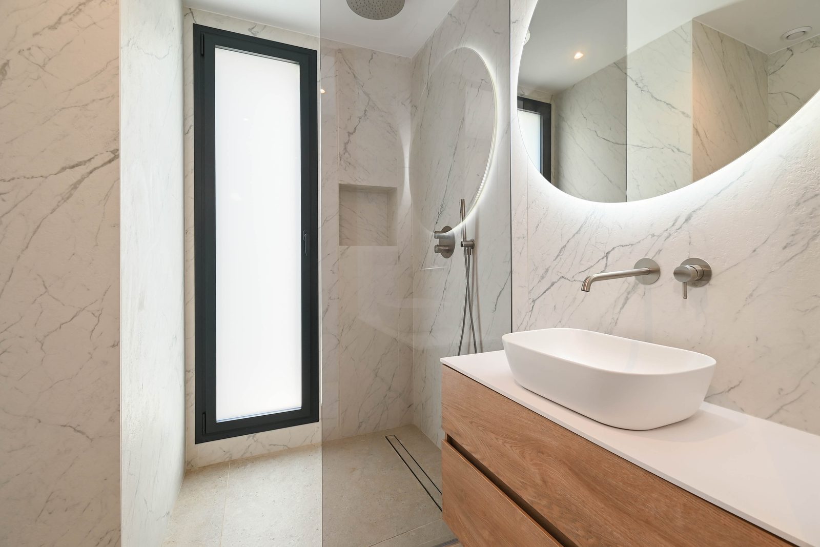 Marble bathroom with walk-in shower, vessel sink and illuminated round mirror in a 4-bedroom villa in Benissa - The Estates