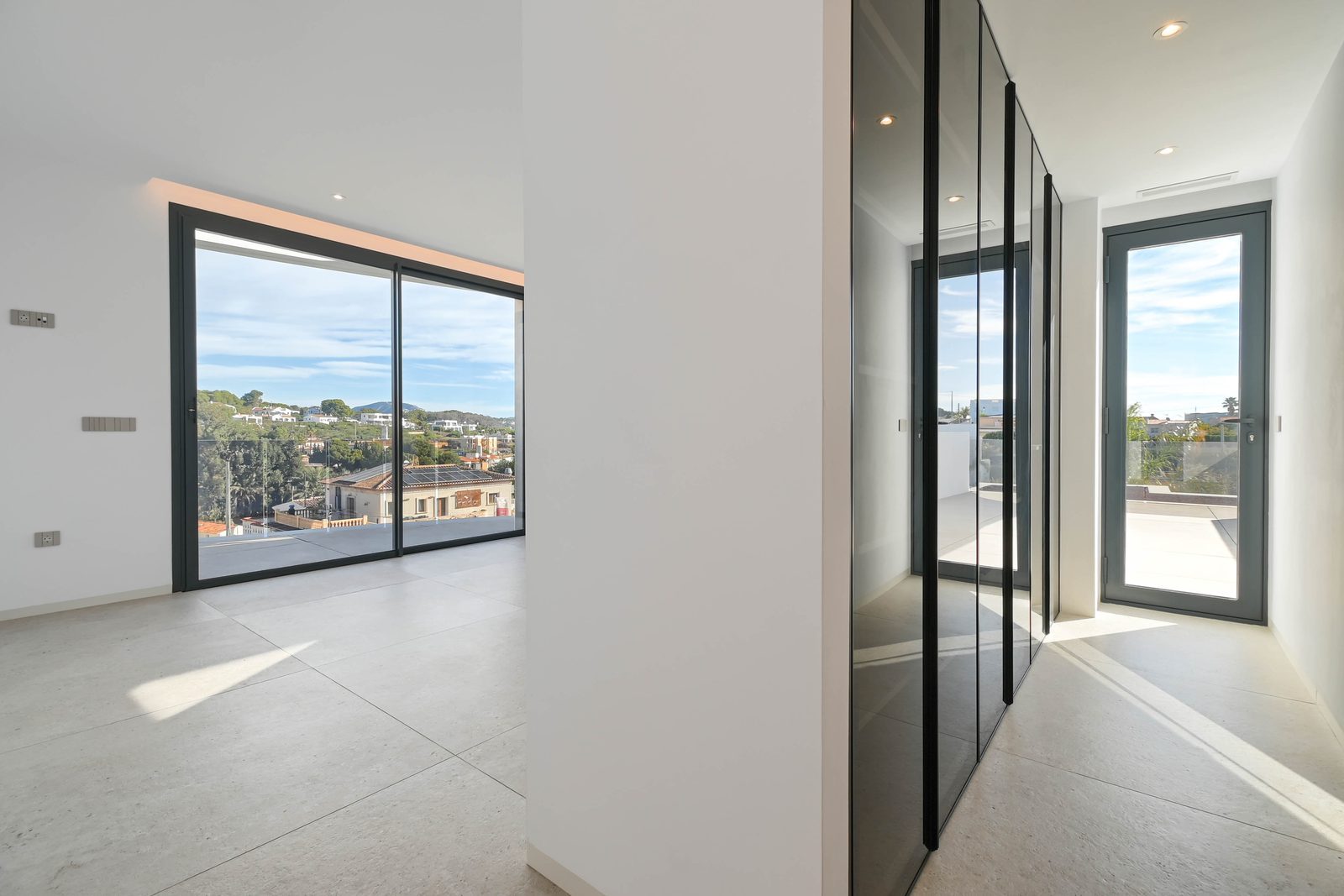 Bright modern interior with floor-to-ceiling windows, mirrored wardrobes and sea views of a 4-bedroom villa in Benissa