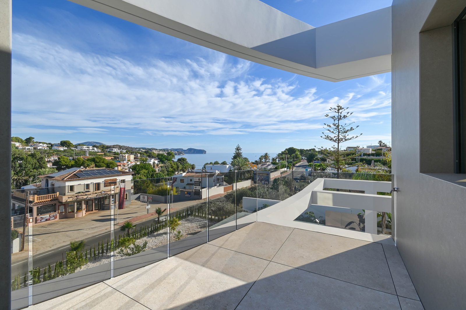 Sea-view terrace with glass balustrade and modern white architecture at a 4-bedroom villa in Benissa - The Estates