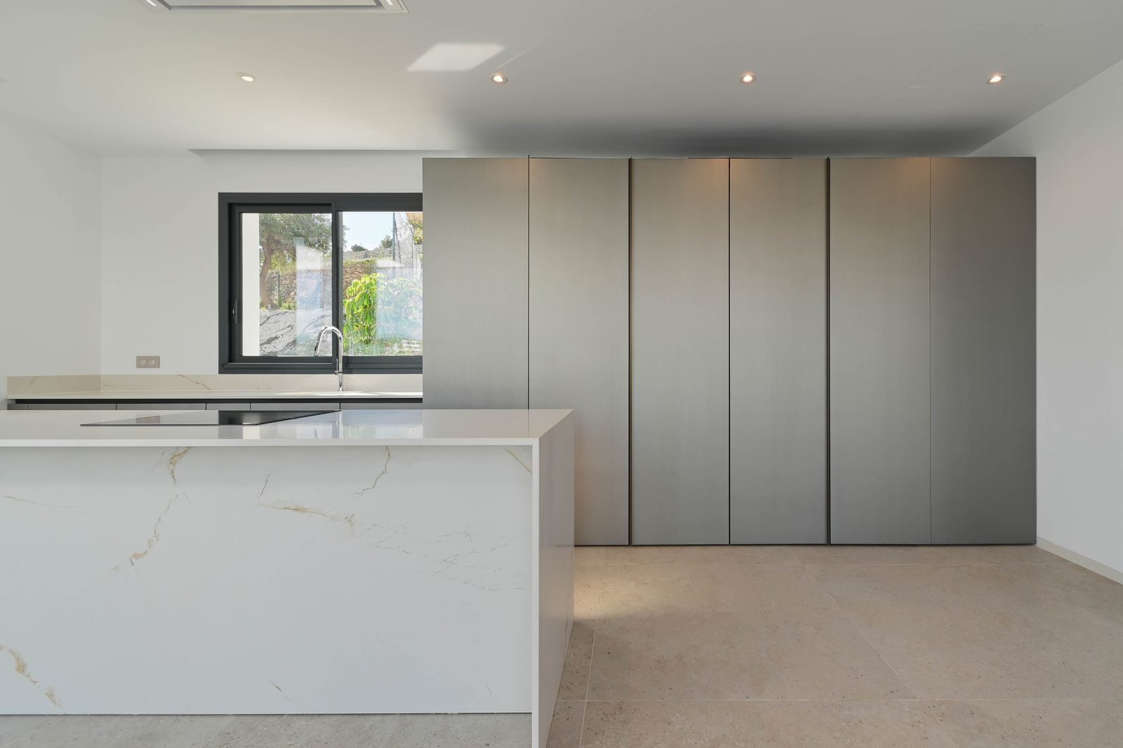 Modern kitchen with marble island and sleek grey cabinetry in a 4-bedroom villa in Benissa - The Estates